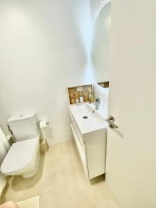 biała łazienka z toaletą i umywalką w obiekcie Barcelona Chic Apartments- Free Parking-10 min by metro from BCN Center w Barcelonie