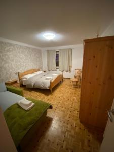 a bedroom with two beds and a table and chairs at affittacamere li di Giuan in Lauco