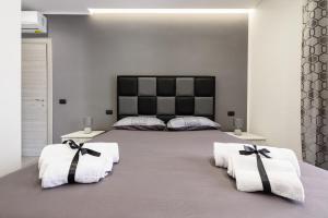 a bedroom with a large bed with towels on it at B&B BELIEVE one room with spa in Naples