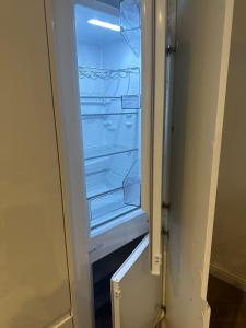 an empty refrigerator with its door open at Knightsbridge Harrods Apartment in London
