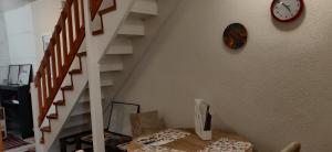 una escalera con un reloj en la pared y una mesa en Apartment Milin by the sea-Zadar, en Zadar