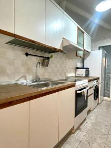 - une cuisine avec des placards blancs et un évier dans l'établissement Skra 3 by Agora Flats, à Thessalonique
