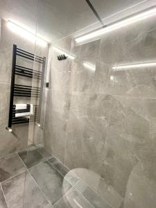 La salle de bains est pourvue d'une douche avec une porte en verre. dans l'établissement Skra 3 by Agora Flats, à Thessalonique