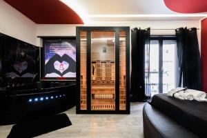 a room with a bathroom with a tub and a television at B&B BELIEVE one room with spa in Naples