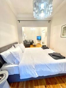 - une chambre avec un grand lit blanc et un lustre dans l'établissement Skra 3 by Agora Flats, à Thessalonique