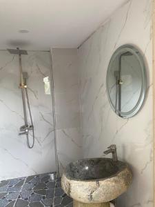a bathroom with a stone sink and a mirror at Ngọc Tiên Farmer Eco Lodge Cat Tiên in Cat Tien