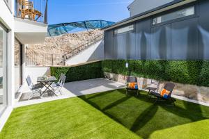 a backyard with a lawn with chairs and a table at Pestana Apartments - Premium in Porto