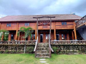 Casa de madera con porche y columpio en Ngọc Tiên Farmer Eco Lodge Cat Tiên, en Cát Tiên