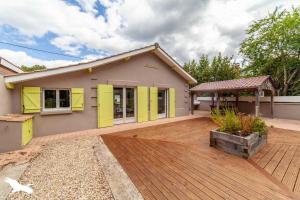 ein Haus mit gelben Türen und einer Holzterrasse in der Unterkunft Pitchounette villa Canaulaise 3ch 8p in Lacanau