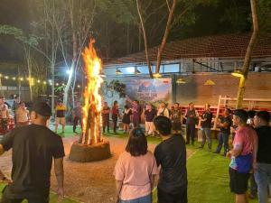カッティエンにあるNgọc Tiên Farmer Eco Lodge Cat Tiênの夜の焚き火の周りに立つ集団
