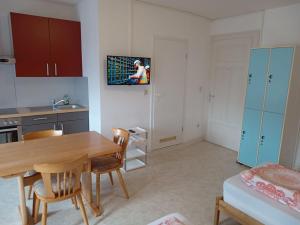 uma cozinha com mesa e cadeiras e uma televisão na parede em Hotel Kremer em Büchenbeuren