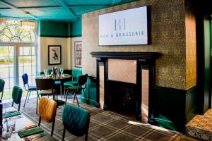 a restaurant with a fireplace and a table and chairs at The Regency Hotel in Solihull