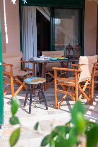 a wooden table and chairs and a table and chairs at Stella's Beach House in Nikiti