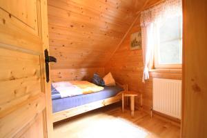 a small bed in a wooden cabin with a window at Almliesl KATH-631 