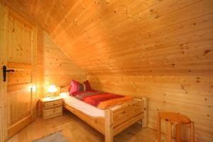 Habitación con cama en una cabaña de madera en Almliesl KATH-631, 