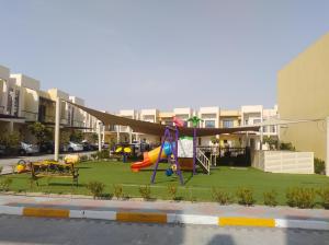 a playground in front of a apartment complex at Amazing One-Bedroom Villa TownHouse in Dubai