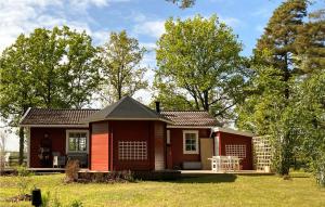 una pequeña casa roja en un patio con árboles en 3 Bedroom Beautiful Home In Hemse, en Hemse