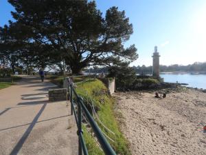 ścieżka wzdłuż plaży z latarnią morską w obiekcie Studio cosy à Bénodet: plage, restos, thalasso à pied, balcon et parking privé - FR-1-481-135 w mieście Bénodet