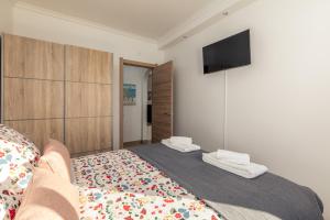 a bedroom with a bed and a flat screen tv at Apartamento Sunset on the Sea in Albufeira