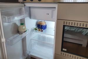 an empty refrigerator with its door open in a kitchen at Self-contained annex with private entrance, double bed, kitchen, bathroom, free car park - Near Cambridge, Duxford Air Museum and Addenbrooke's Hospital in Cambridge