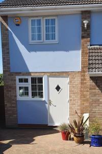 a house with a blue door and a window at Self-contained annex with private entrance, double bed, kitchen, bathroom, free car park - Near Cambridge, Duxford Air Museum and Addenbrooke's Hospital in Cambridge