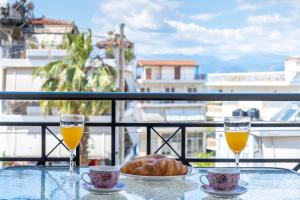a table with two glasses of orange juice and bread at Nafplio view in Nafplio