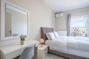 a white bedroom with a bed and a mirror at Nafplio view in Nafplio