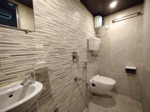 a bathroom with a toilet and a sink at Hotel Eros - Near Mumbai International Airport T2 in Mumbai