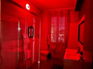 a red bathroom with a toilet and a sink at JR HOME 1 in Corsico