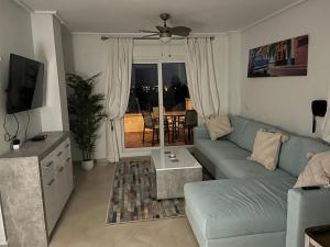 a living room with a blue couch and a television at Casa Pez Espada-A Murcia Holiday Rentals Property in Roldán