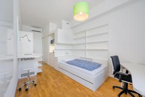 a white room with a bed and a desk and a chair at Dean's Home Budapest in Budapest