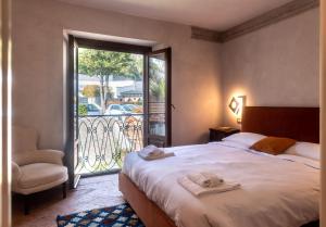 - une chambre avec un lit, une chaise et une fenêtre dans l'établissement Leoni 7, à Menaggio