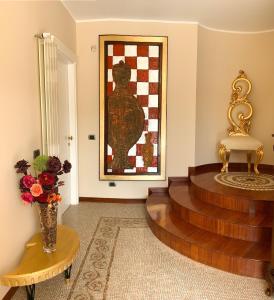 una sala de estar con un jarrón de flores y una pintura en B&B Guarini, en Casamassima