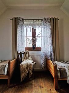 a bedroom with two beds and a window at Na Przypiecku in Piecki