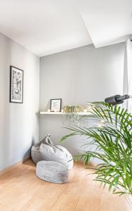 una sala de estar con una planta y una pared blanca en NiceOne Apartment Number 7 - W samym Centrum!, en Wroclaw