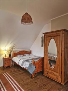 a bedroom with a wooden bed and a mirror at Na Przypiecku in Piecki