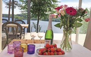 a table with a bottle of wine and flowers and strawberries at Beautiful Home In Aplared With 2 Bedrooms, Sauna And Wifi in Aplared