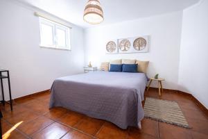 een slaapkamer met een bed in een witte kamer bij Cem Sentido - Alentejo Apartments in Portalegre