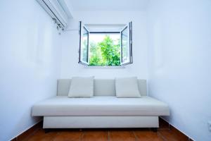 een witte bank in een kamer met een raam bij Cem Sentido - Alentejo Apartments in Portalegre