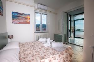 1 dormitorio con 1 cama grande y balcón en 162 - La Veranda Sull'Acqua, Fronte e Vista Mare Riva Trigoso, POSTO AUTO PRIVATO en Sestri Levante