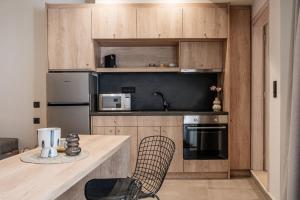 uma cozinha com armários de madeira e um aparelho preto em Vinnies Homes em Heraclião
