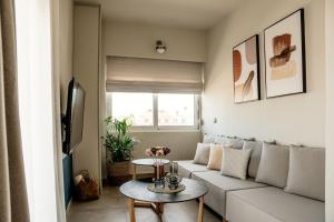een woonkamer met een witte bank en een tafel bij Vinnies Homes in Heraklion