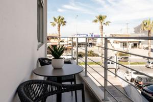een balkon met een tafel en stoelen en uitzicht op een straat bij Vinnies Homes in Heraklion