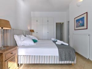 een slaapkamer met een groot wit bed met witte kussens bij VILLA MIA PAROS in Agia Irini Paros