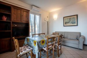 a living room with a table with chairs and a couch at 162 - La Veranda Sull'Acqua, Fronte e Vista Mare Riva Trigoso, POSTO AUTO PRIVATO in Sestri Levante +32 photos