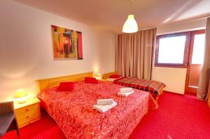 a hotel room with two beds with red sheets at Villa Patriot - Penzión in Vyšné Ružbachy