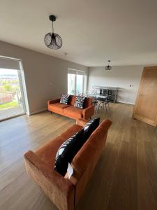 a living room with two couches and a table at Century Wharf by Urban Space in Cardiff