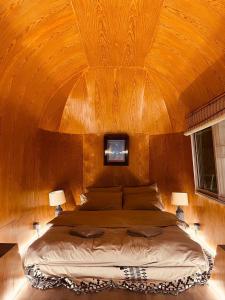 sypialnia z dużym łóżkiem i drewnianym sufitem w obiekcie Greenspace Living w mieście Ban Tha Phae