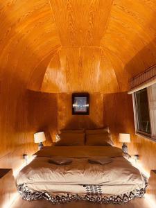Un dormitorio con una cama grande con techo de madera. en Greenspace Living, en Ban Tha Phae