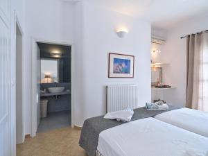 een slaapkamer met 2 bedden en een badkamer bij VILLA MIA PAROS in Agia Irini Paros